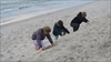 Børnene bestiger sandbakke på stranden.